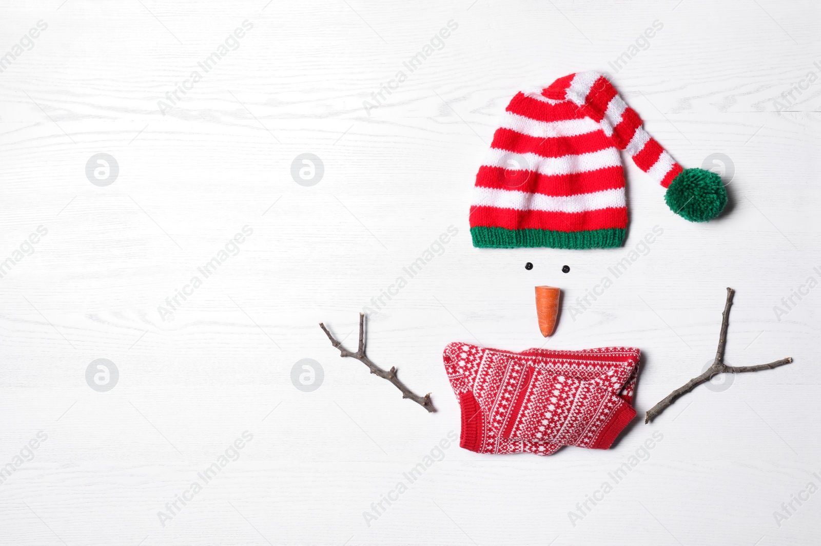 Photo of Funny snowman made with different elements on white wooden background, flat lay. Space for text