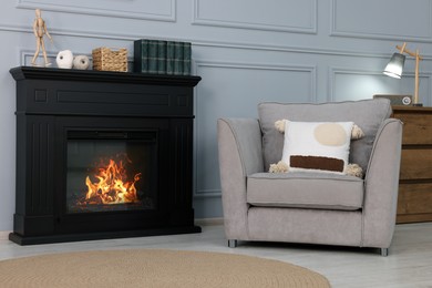 Black stylish fireplace near armchair in cosy living room