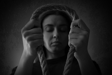 Image of Depressed woman with rope noose, low angle view. Suicide concept