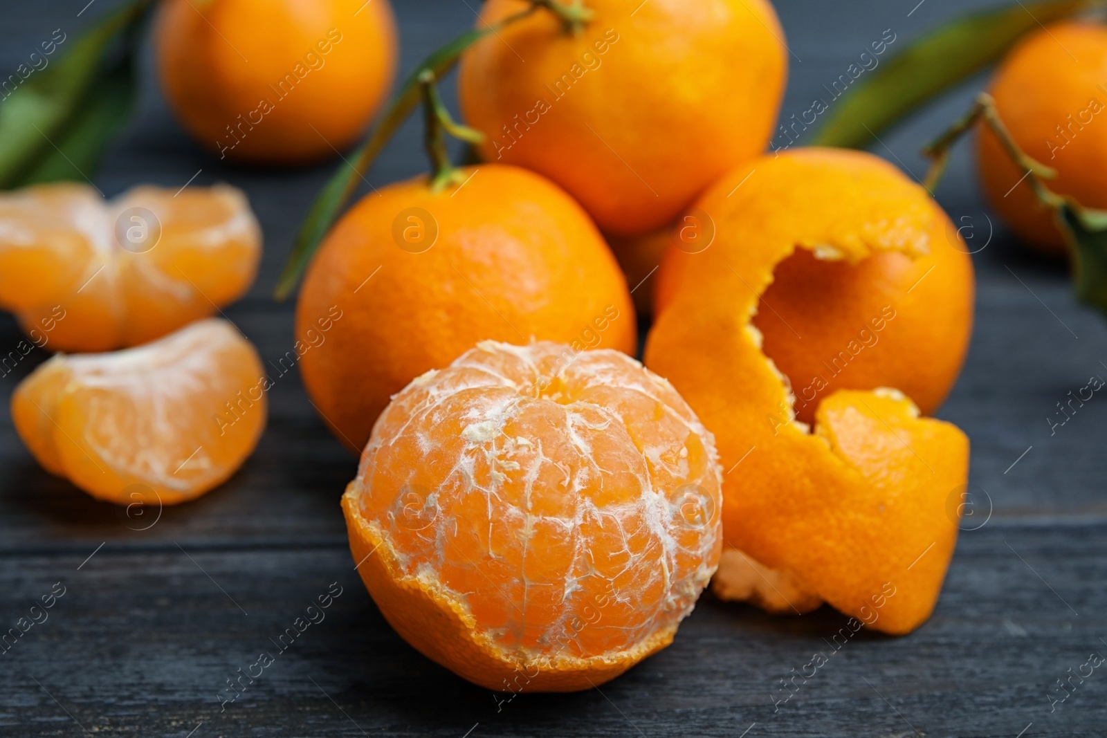 Photo of Fresh peeled and whole tangerines on table