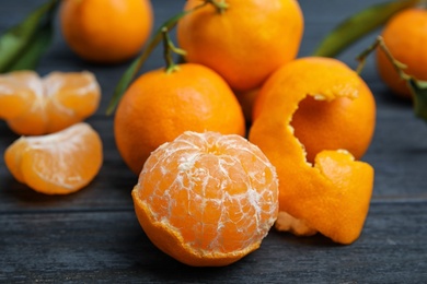 Fresh peeled and whole tangerines on table