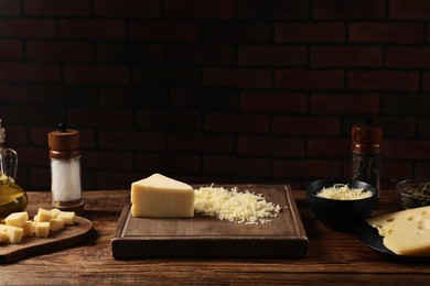 Different types of cheese and spices on wooden table. Space for text