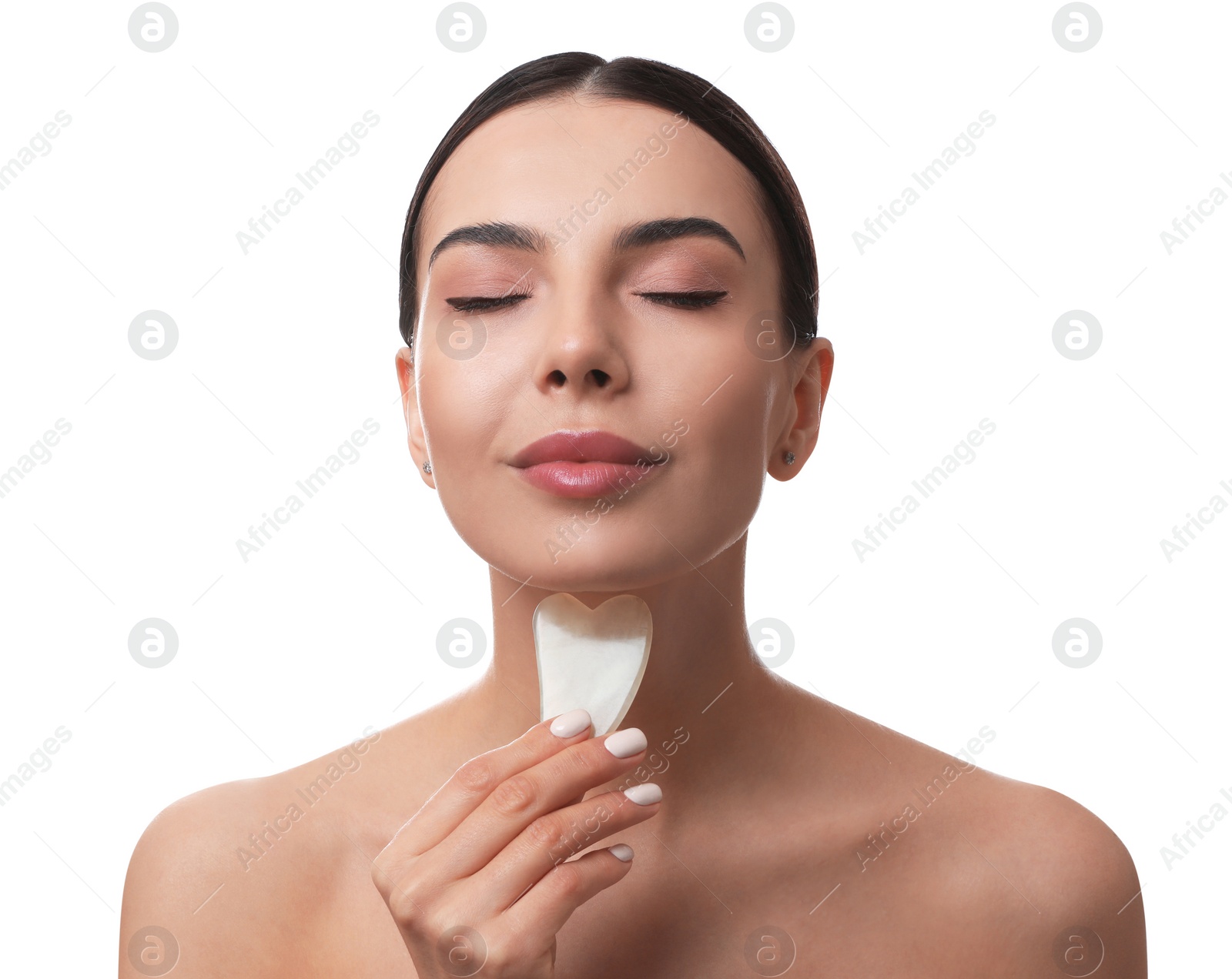 Photo of Beautiful young woman doing facial massage with gua sha tool on white background