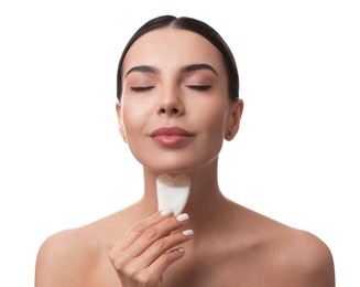 Beautiful young woman doing facial massage with gua sha tool on white background