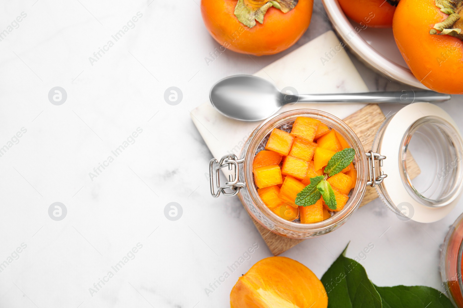 Photo of Delicious dessert with persimmon on table, flat lay. Space for text