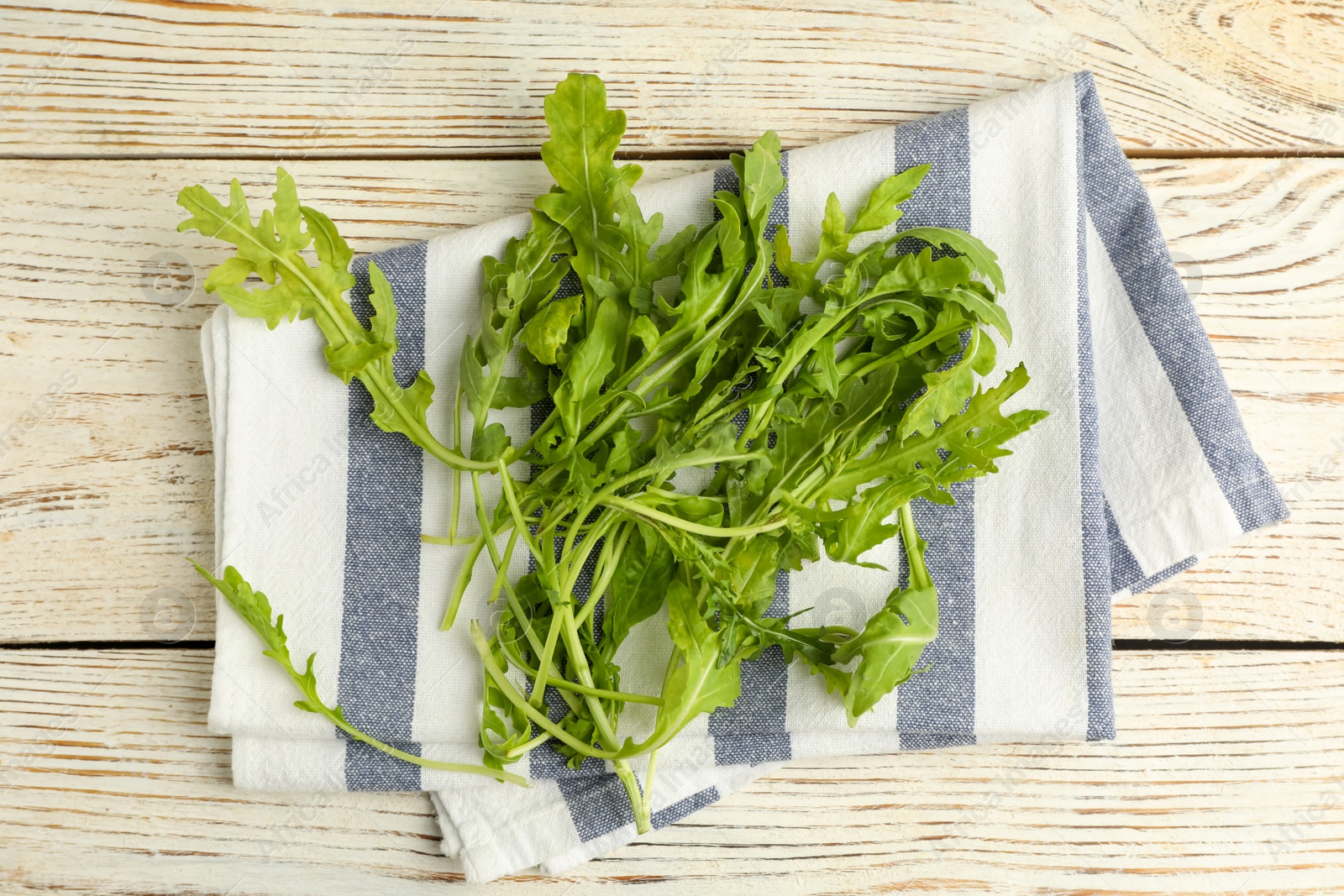 Photo of Fresh arugula on white wooden table, flat lay