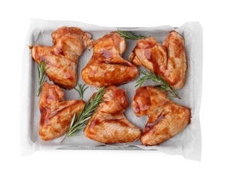 Photo of Raw marinated chicken wings and rosemary isolated on white, top view