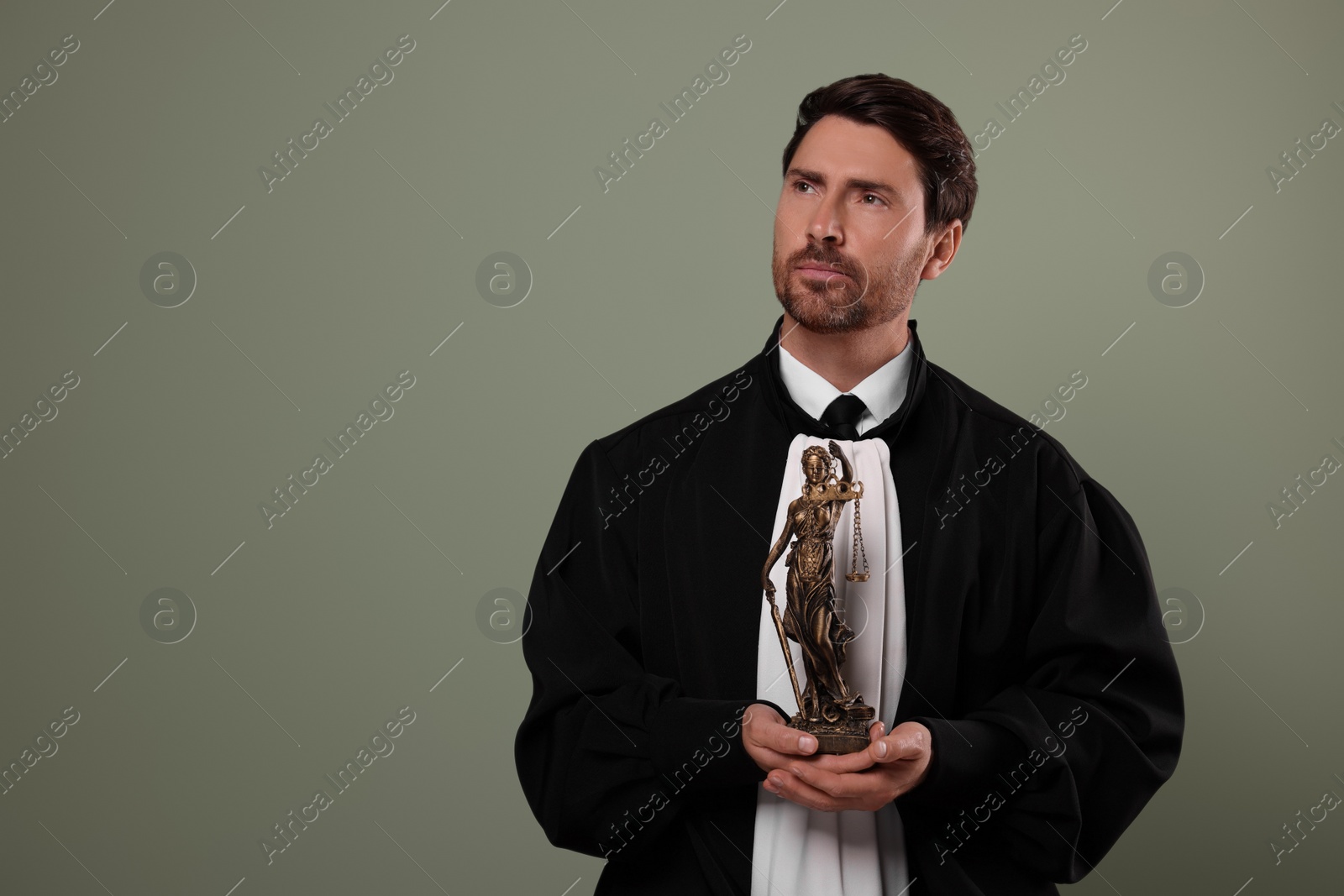 Photo of Judge with figure of Lady Justice on green background. Space for text
