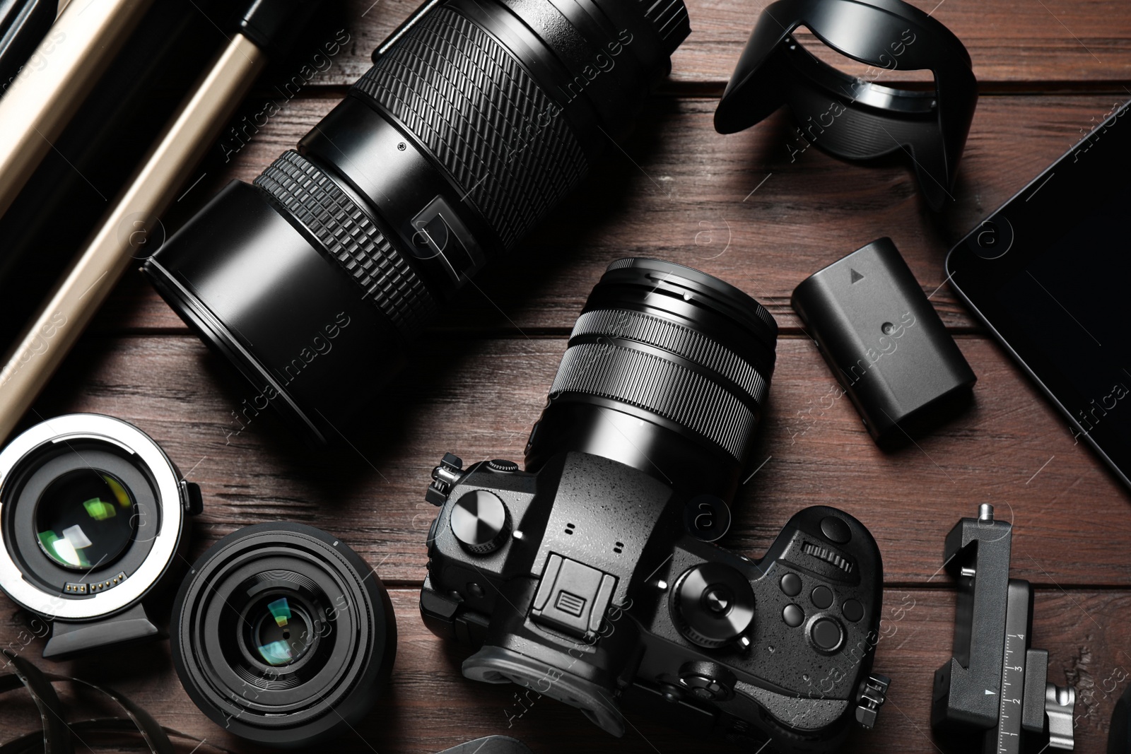 Photo of Flat lay composition with camera and video production equipment on brown wooden background