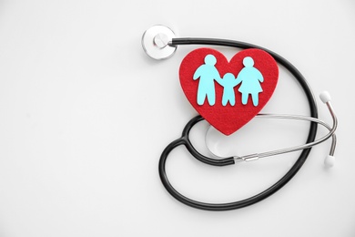 Photo of Flat lay composition with paper family cutout, red heart and stethoscope on light background