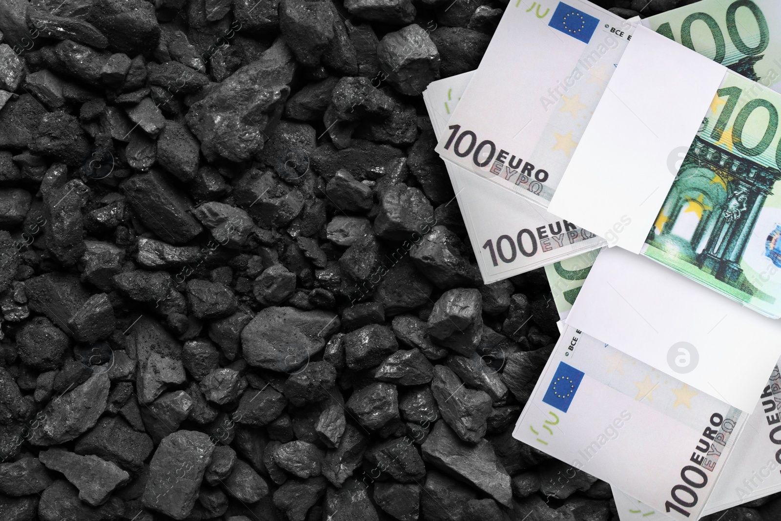 Image of Euro banknotes on pieces of coal, top view. Resource price