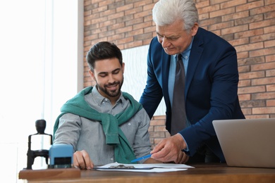 Photo of Senior notary working with client in office