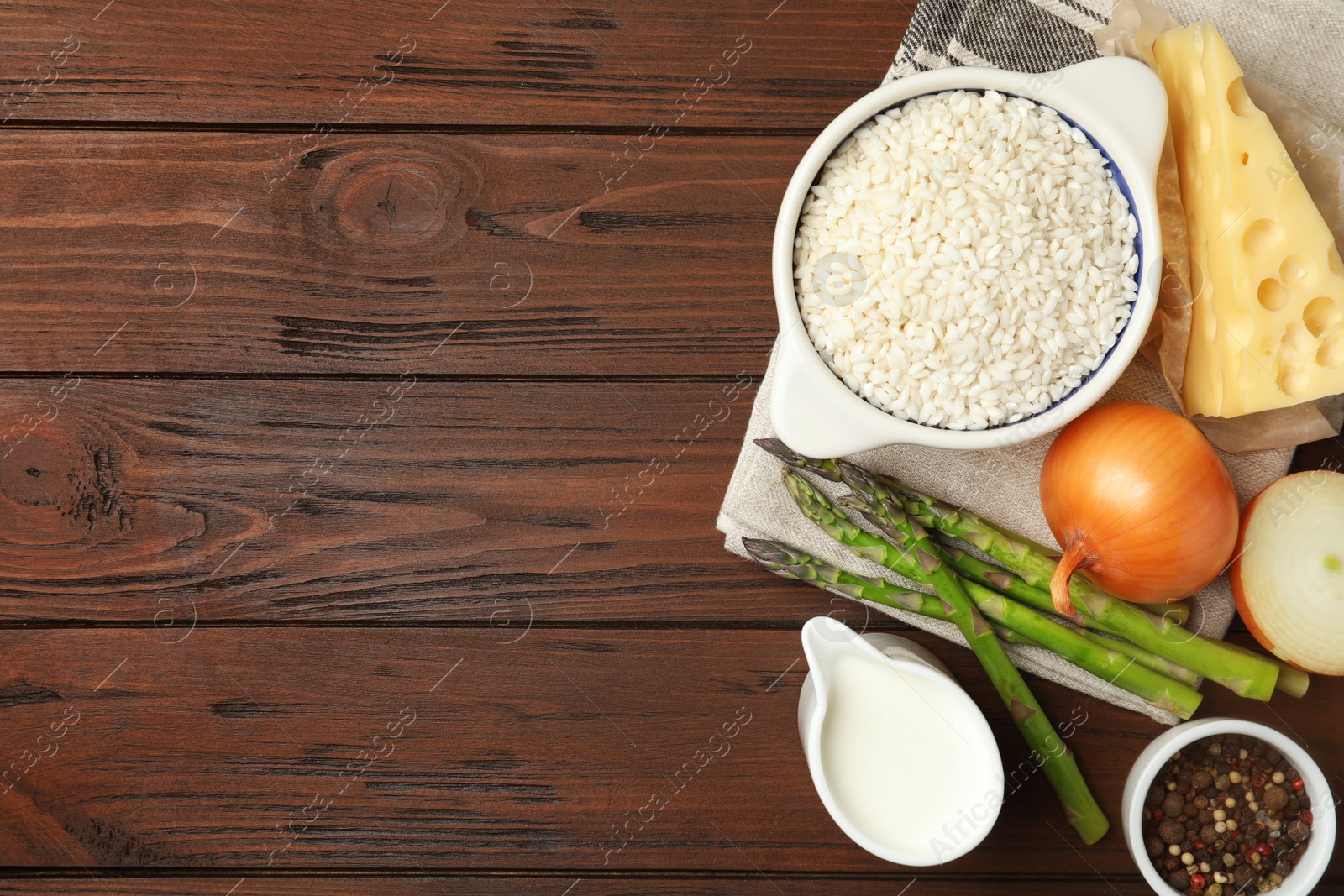 Photo of Flat lay composition with different ingredients on wooden table, space for text. Risotto recipe