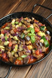 Photo of Delicious ratatouille in baking dish on wooden table, closeup