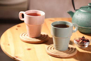 Photo of Aromatic tea, dry flower petals and teapot on wooden table