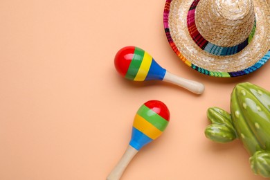 Photo of Colorful maracas, toy cactus and sombrero hat on beige background, flat lay with space for text. Musical instrument