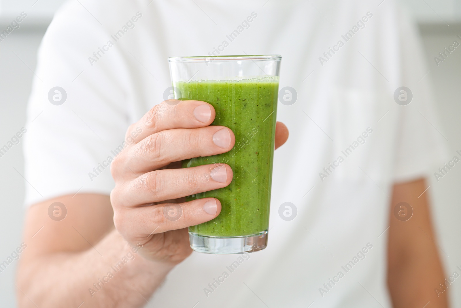 Photo of Man holding glass of delicious smoothie, closeup