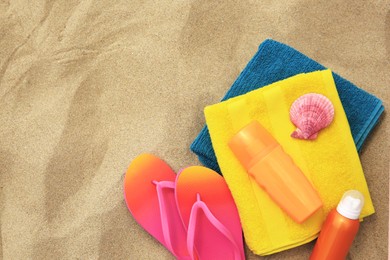 Photo of Flat lay composition with sunscreens on sand, space for text. Sun protection care