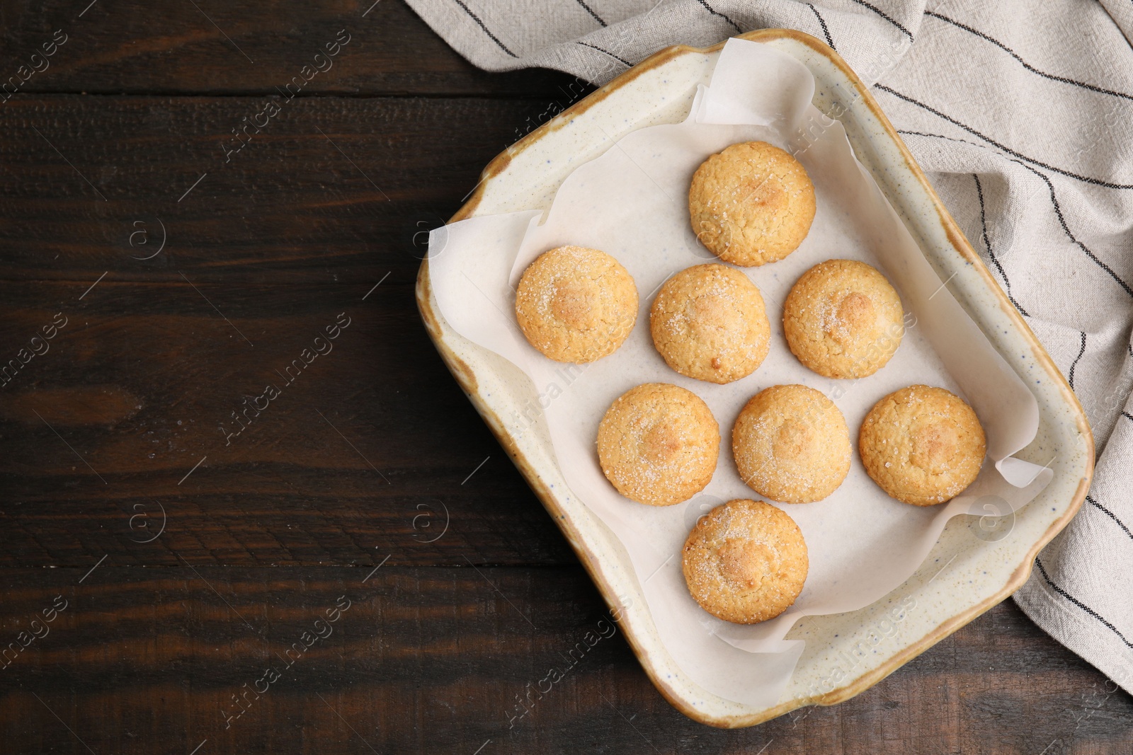 Photo of Tasty sweet sugar cookies in baking dish on wooden table, top view. Space for text