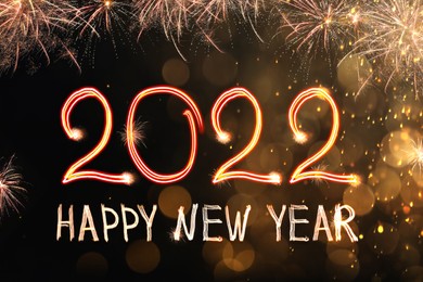 Image of Bright text Happy New 2022 Year made of firework on dark background. Greeting card design