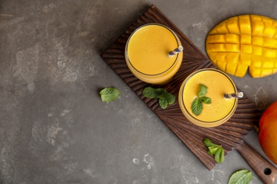 Glasses of fresh mango drink and fruits on table. Space for text