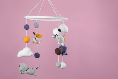 Cute baby crib mobile on pink background. Space for text