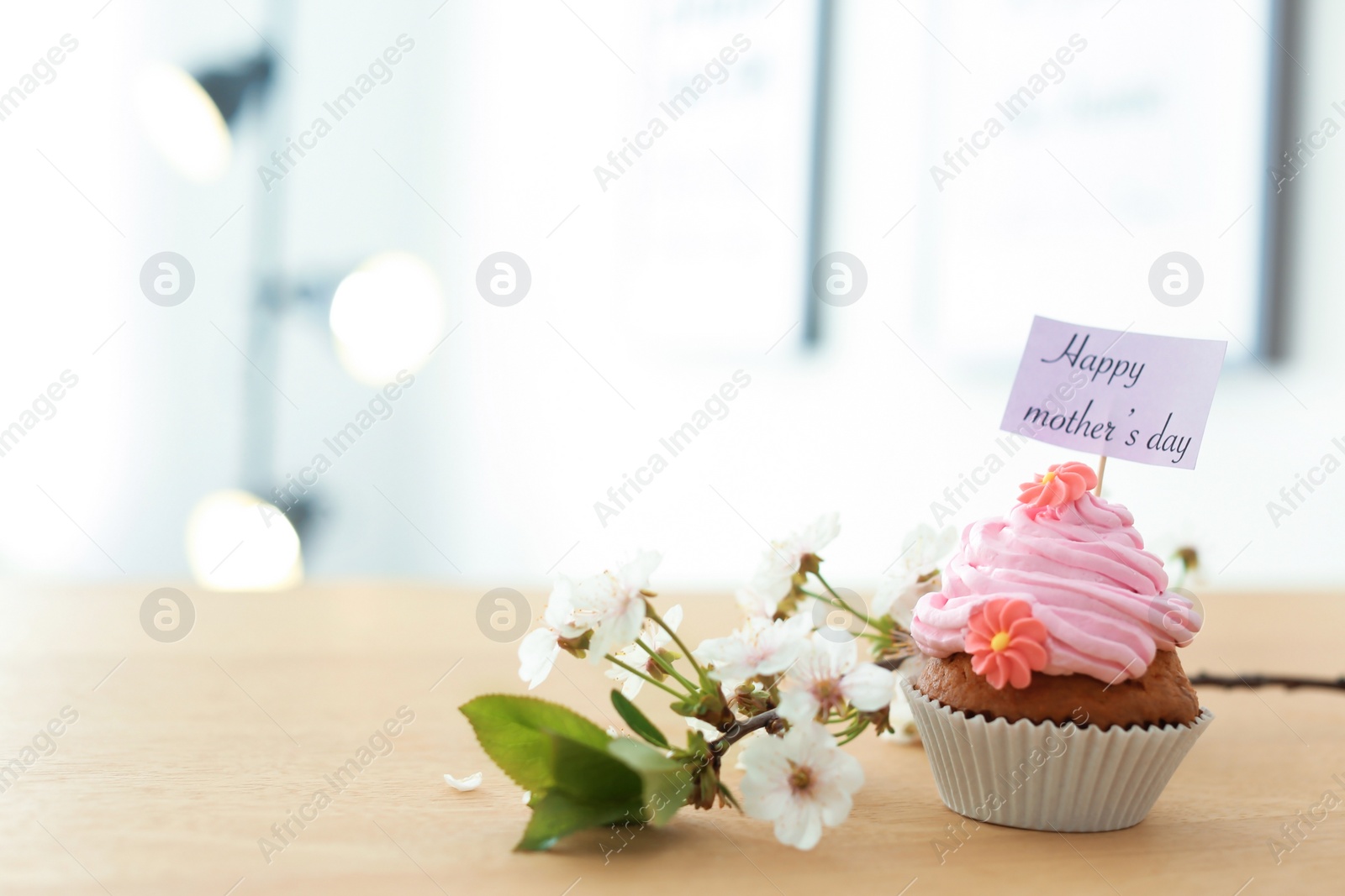 Photo of Tasty cupcake and flowers for Mother's Day on table