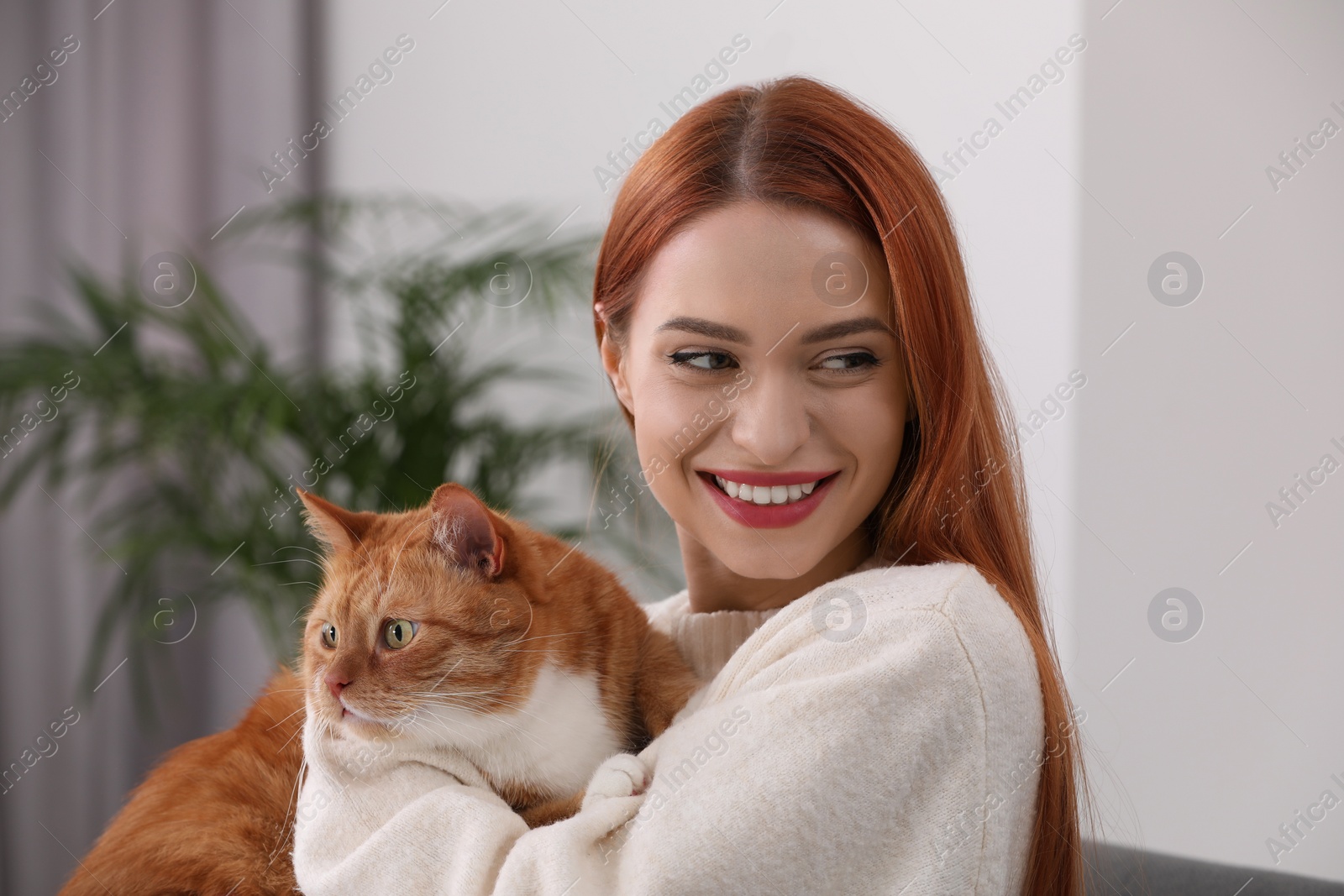 Photo of Happy woman with her cute cat at home