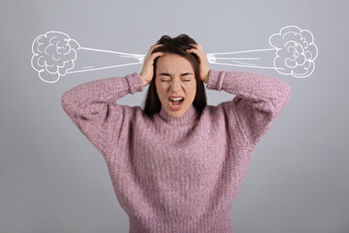 Stressed and upset young woman on light grey background