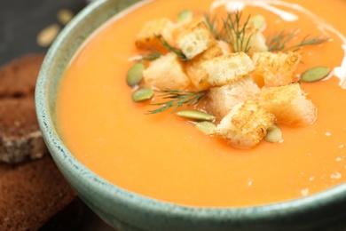 Photo of Delicious creamy pumpkin soup in bowl, closeup