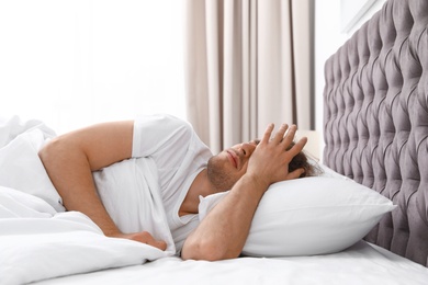 Photo of Sleepy young man lying on pillow at home. Bedtime