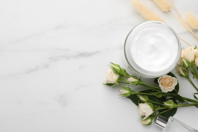 Photo of Jar of hand cream and roses on white marble table, flat lay. Space for text
