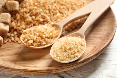 Spoons and brown sugar on table, closeup