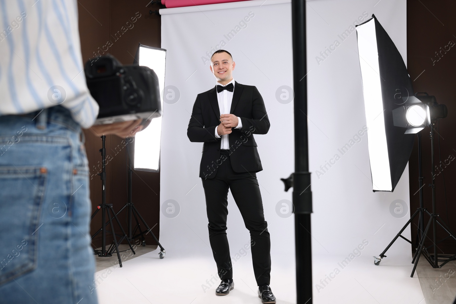 Photo of Handsome model posing for professional photographer in studio