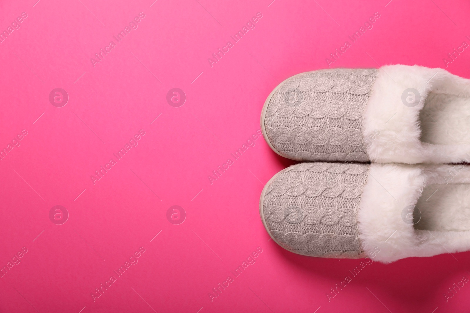 Photo of Pair of beautiful soft slippers on pink background, top view. Space for text