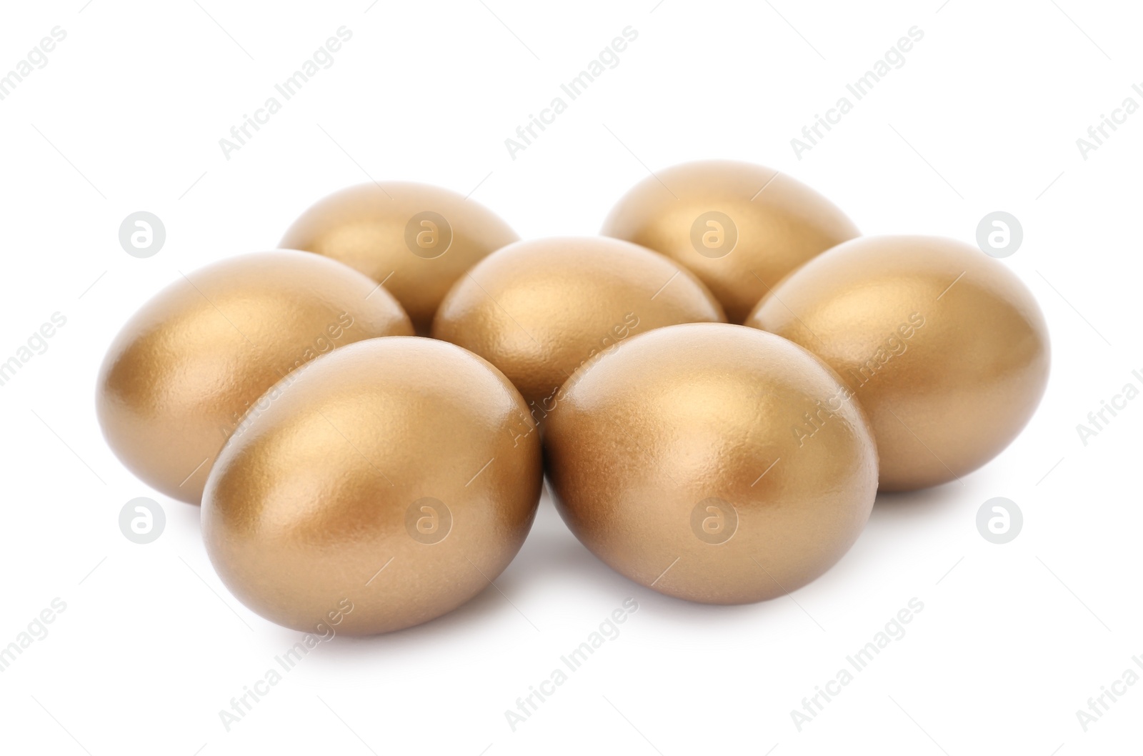 Photo of Many shiny golden eggs on white background