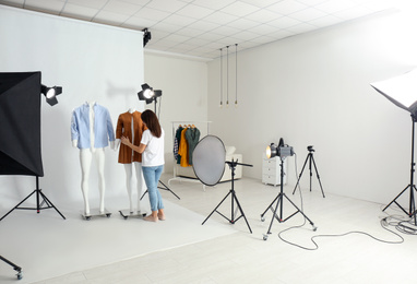 Woman putting clothes on ghost mannequins in professional photo studio