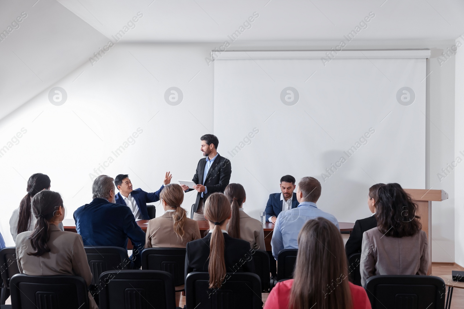 Photo of Business conference. People in meeting room listening to speaker report