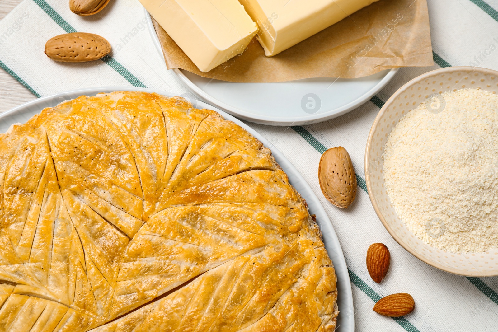 Photo of Traditional galette des rois and ingredients on table, flat lay