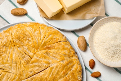 Photo of Traditional galette des rois and ingredients on table, flat lay