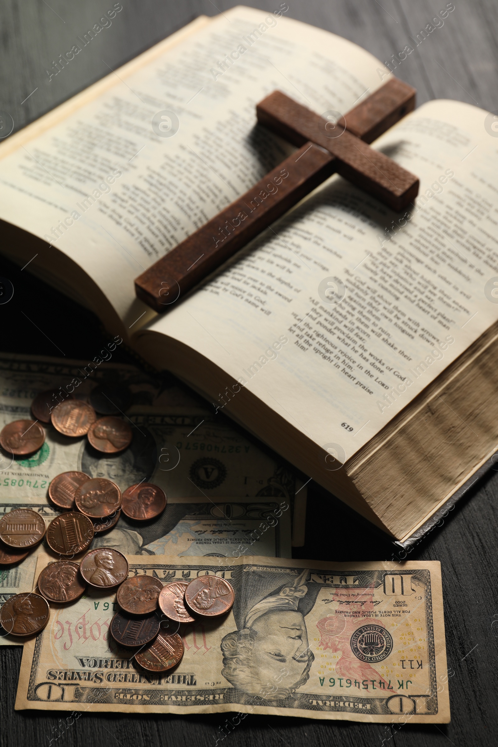 Photo of Donate and give concept. Coins, dollar banknotes, cross and Bible on wooden table, closeup