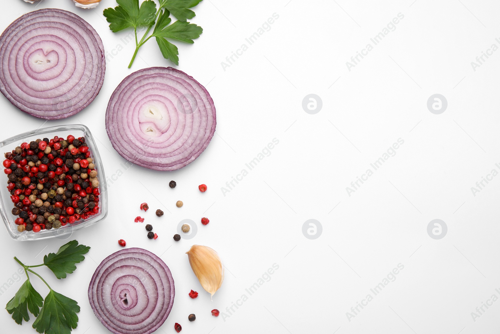 Photo of Fresh red onions, garlic, parsley and spices on white background, flat lay. Space for text