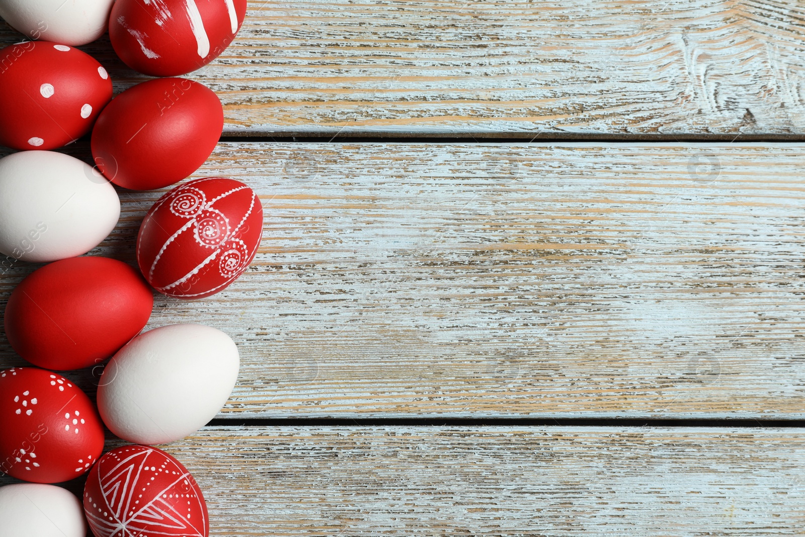 Photo of Flat lay composition of painted red Easter eggs on wooden table, space for text