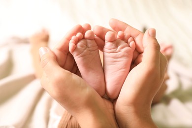 Mother and her newborn baby on bed, closeup view