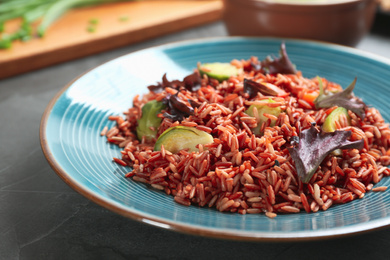 Tasty brown rice with vegetables on table, closeup