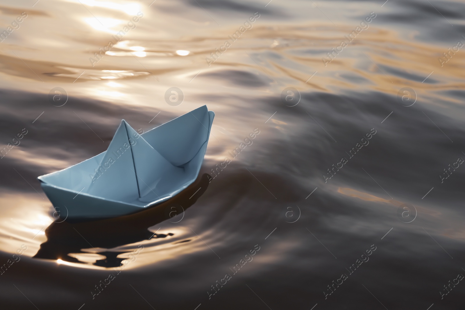 Photo of White paper boat floating on river, space for text