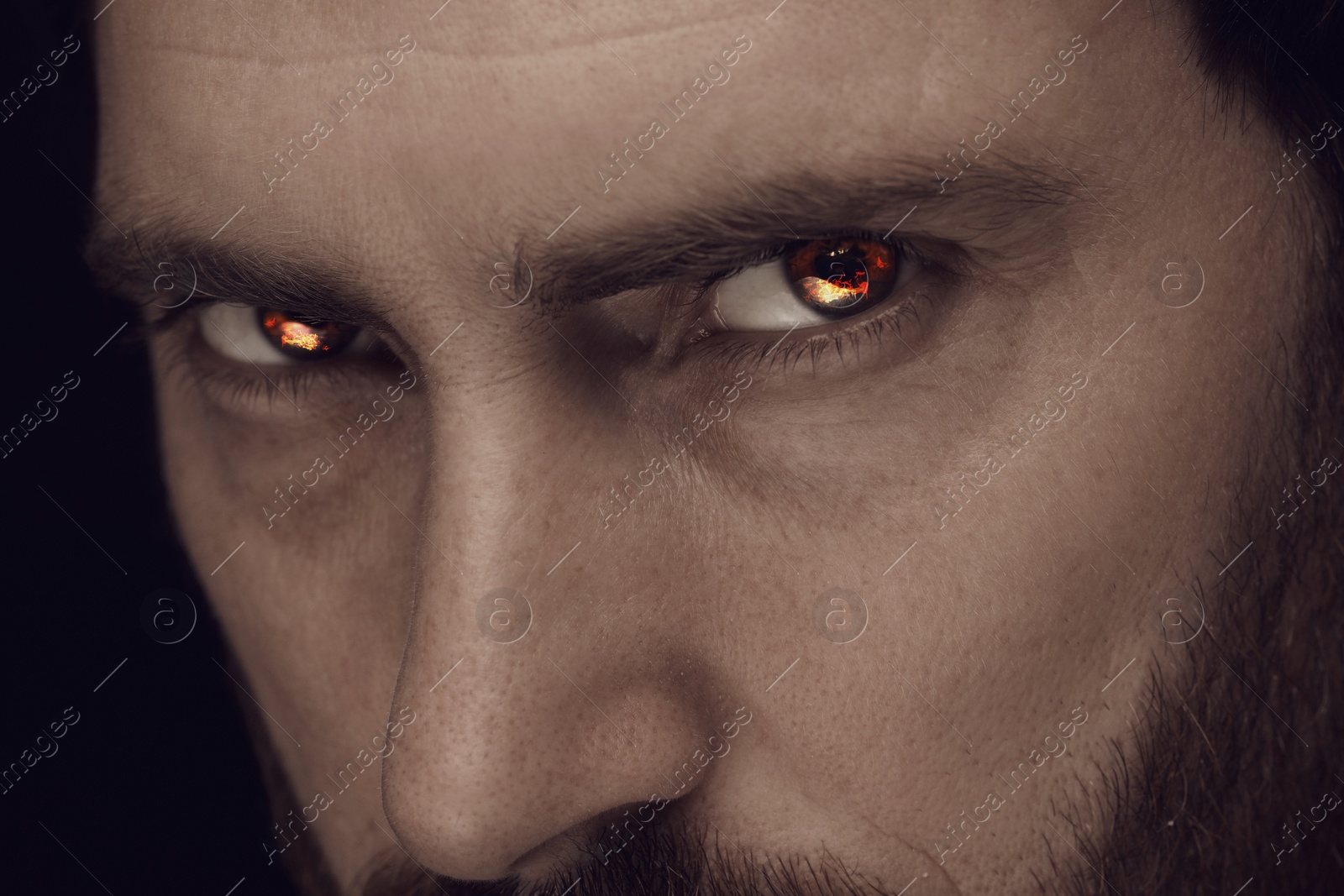 Image of Man with fire burning in his eyes, closeup. Evil eye