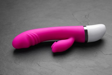 Photo of Pink vaginal vibrator on black background. Sex toy