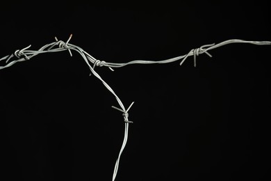 Photo of Shiny metal barbed wire on black background