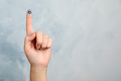 Photo of Woman showing blue circle drawn on finger against color background, closeup and space for text. World Diabetes Day